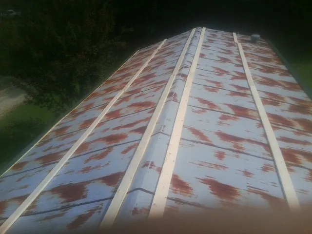 Rusted metal roof panels with new wood purlins before replacement — Storm Damage Roof Repair in Doswell by Roofing Brothers