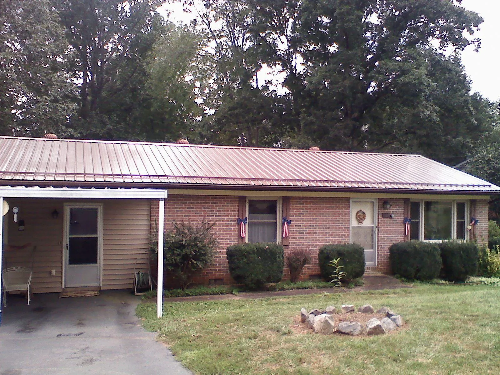 Bronze metal roof and carport on a brick ranch home — Roof Repair work by our crew in Doswell